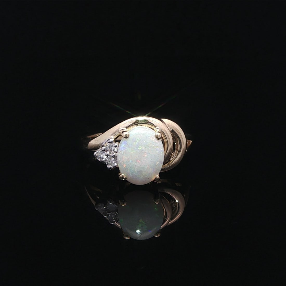 Opal and Diamond Cluster Swirl Band in 14k Yellow Gold Size 7: Opal and Diamond Cluster Swirl Band in 14k Yellow Gold Size 7 This elegant cocktail ring features a natural opal cabochon as its centerpiece, displaying vibrant green and orange hues. Accented by thre