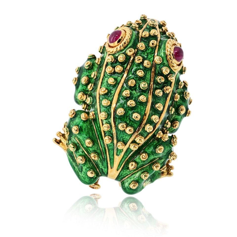 David Webb Frog Brooch 18K Yellow Gold Ruby Eyes: David Webb Frog Brooch 18K Yellow Gold Ruby Eyes This David Webb frog brooch is crafted from 18K yellow gold and features richly textured green enamel with vivid ruby cabochon eyes. The design is acce