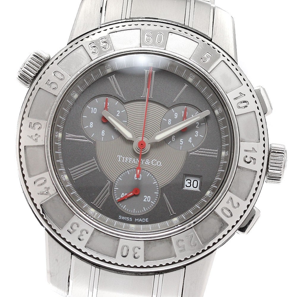Tiffany Mark T-57 stainless steel quartz chronograph date men's wristwatch: Tiffany Mark T-57 stainless steel quartz chronograph date men's wristwatch This pre-owned Tiffany & Co. Mark T-57 chronograph wristwatch features a stainless steel case and band with a gray dial. It i