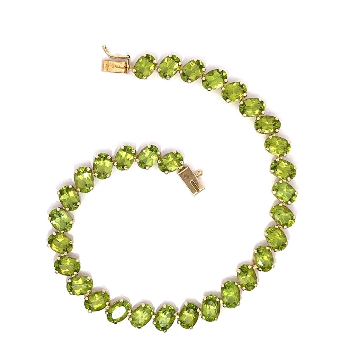 14k Yellow Gold 29ctw Oval Peridot Tennis Bracelet 8.25in: 14k Yellow Gold 29ctw Oval Peridot Tennis Bracelet 8.25in This stunning tennis bracelet features a diagonal design crafted from solid 14k yellow gold, showcasing a total of 31 natural genuine peridots