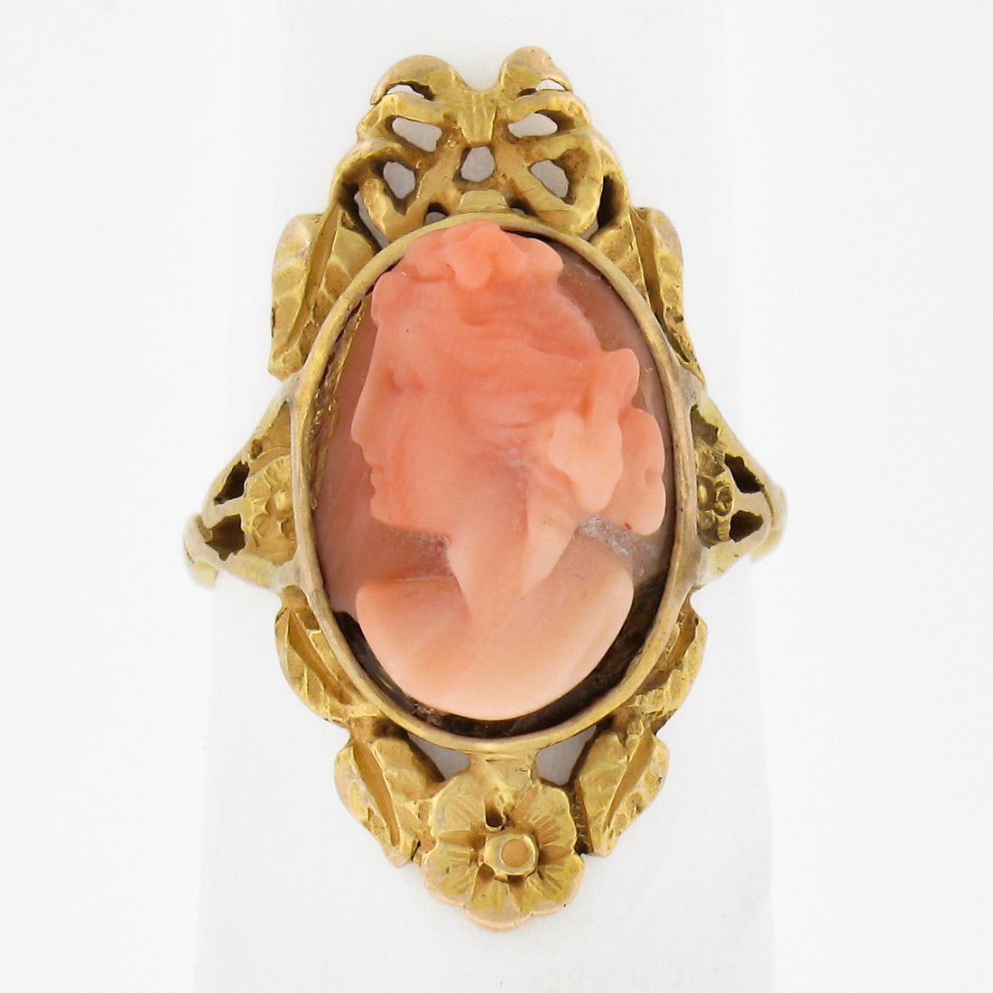 Antique 14k Yellow Gold Coral Cameo Flower Frame Ring: Antique 14k Yellow Gold Coral Cameo Flower Frame Ring This exquisite antique ring features a stunning 14k yellow gold bezel setting that beautifully showcases an oval carved coral cameo. The cameo fea