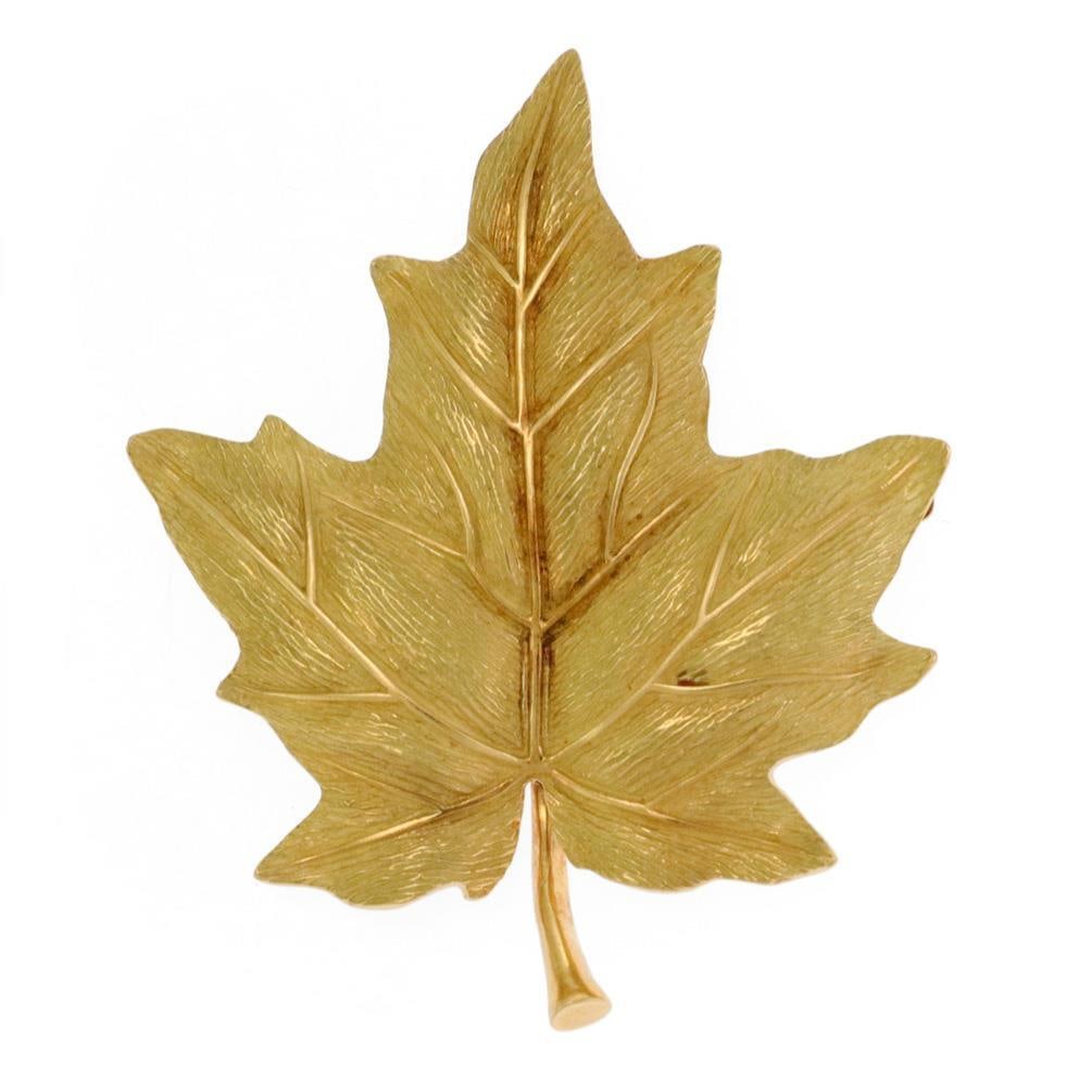 Tiffany Co Maple Leaf Brooch in 18k Yellow Gold: Tiffany Co Maple Leaf Brooch in 18k Yellow Gold This exquisite brooch from Tiffany & Co. showcases a stunning maple leaf design meticulously crafted from 18k yellow gold. The lifelike textured surface