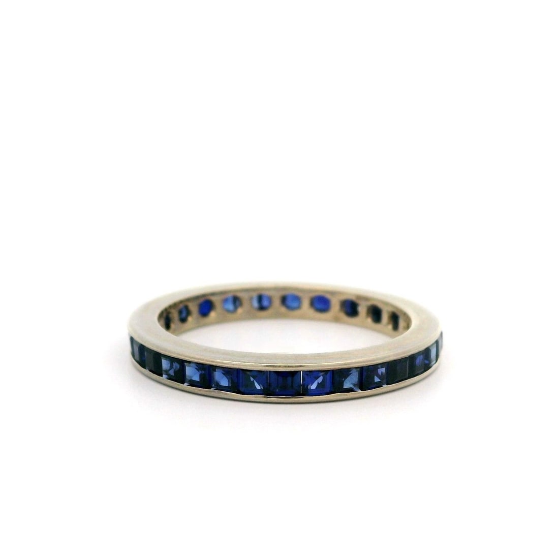 Vintage 14k White Gold Sapphire Stackable Band Ring: Vintage 14k White Gold Sapphire Stackable Band Ring This vintage stackable band ring features a sophisticated design crafted from solid 14k white gold. It showcases numerous synthetic sapphires, each 