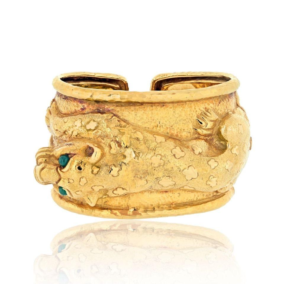 David Webb 18K Yellow Gold Repousse Leopard Bracelet with Emerald Eyes: David Webb 18K Yellow Gold Repousse Leopard Bracelet with Emerald Eyes This stunning bracelet from David Webb features a remarkable repousse leopard design, expertly crafted in 18K yellow gold. The le