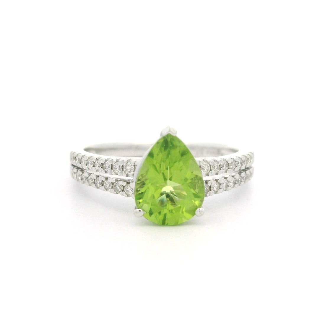 14k White Gold 1.50ctw Pear Peridot Diamond Split Shank Ring: 14k White Gold 1.50ctw Pear Peridot Diamond Split Shank Ring This exquisite cocktail ring features a stunning natural pear cut peridot, securely set in solid 14k white gold. The vibrant light vivid gr