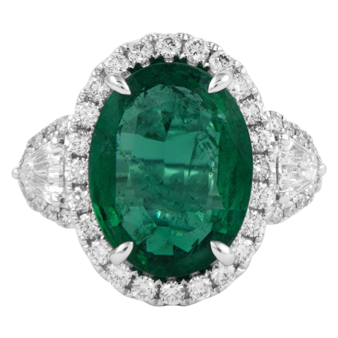 GIA 5.30ct Emerald Diamond 3-Stone Ring 18k White Gold: GIA 5.30ct Emerald Diamond 3-Stone Ring 18k White Gold This exquisite 3-stone ring features a stunning 5.30 carat oval emerald set in a contemporary design, complemented by a halo of diamonds. Crafted