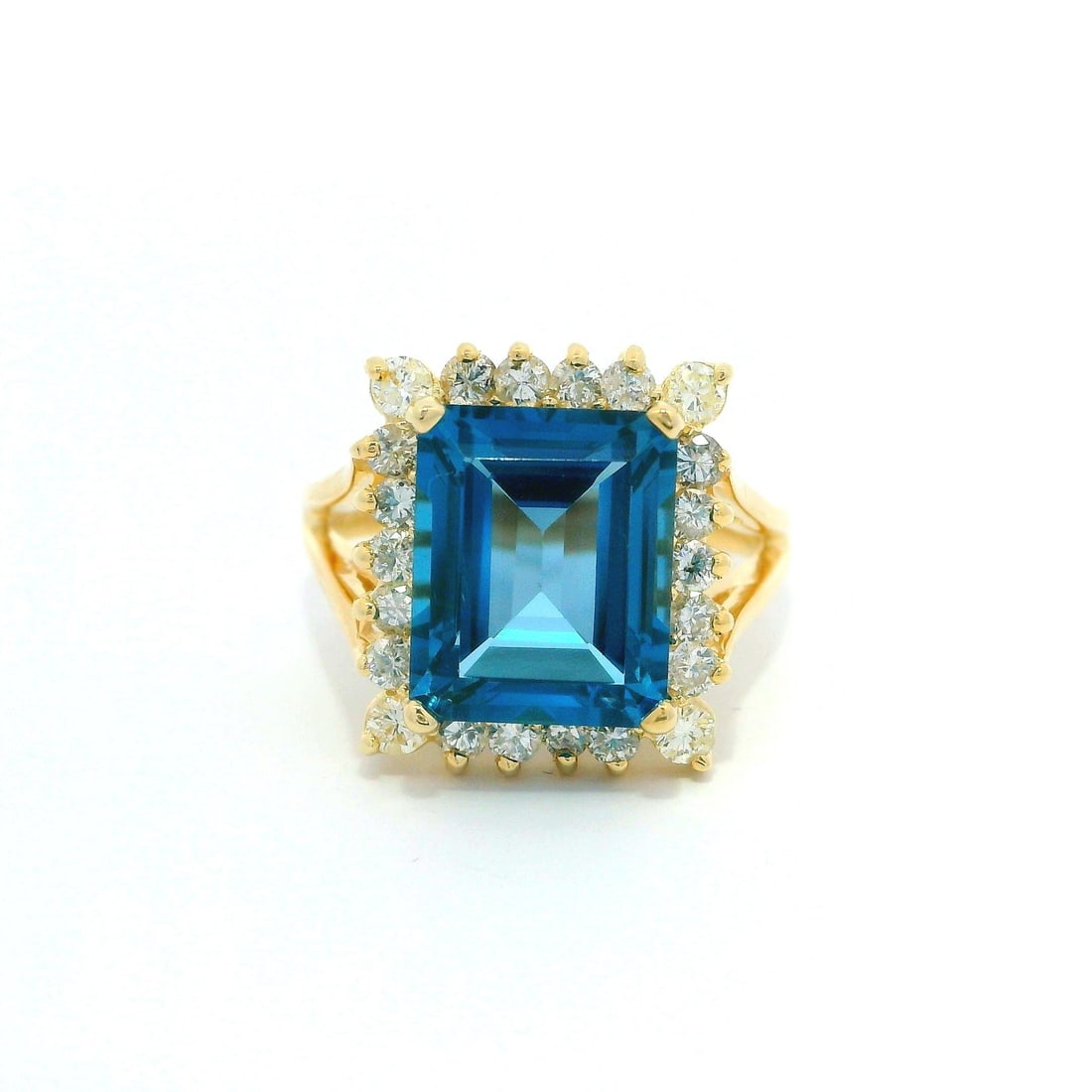 14k Yellow Gold Halo Diamond Cocktail Ring Blue Topaz 0.44ctw: 14k Yellow Gold Halo Diamond Cocktail Ring Blue Topaz 0.44ctw This stunning cocktail ring features a captivating emerald-cut blue topaz at its center, measuring approximately 11x9mm. Surrounded by a s