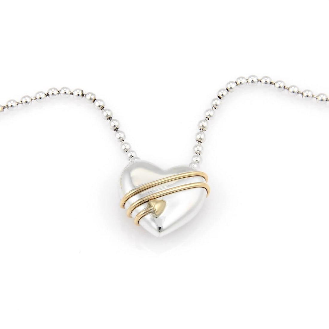 Tiffany & Co. 1994 Cupid's Heart Pendant Necklace 18k Gold Silver: Tiffany & Co. 1994 Cupid's Heart Pendant Necklace 18k Gold Silver This exquisite necklace from Tiffany & Co.'s Cupid collection features a beautifully crafted heart pendant adorned with a yellow gold 