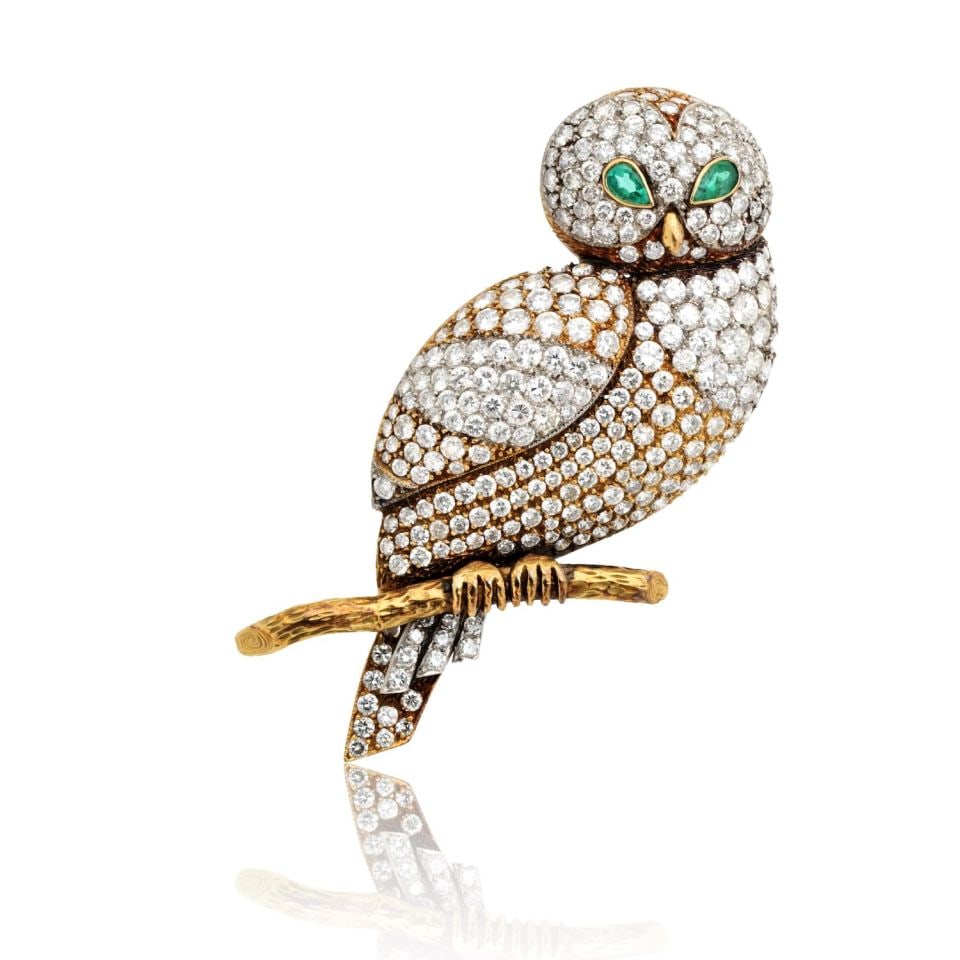18K Yellow Gold Owl Brooch with 8.5 Carats Diamonds and Emerald Eyes: 18K Yellow Gold Owl Brooch with 8.5 Carats Diamonds and Emerald Eyes This exquisite 18K Yellow Gold brooch features a charming owl perched on a branch, showcasing a stunning array of round cut diamond