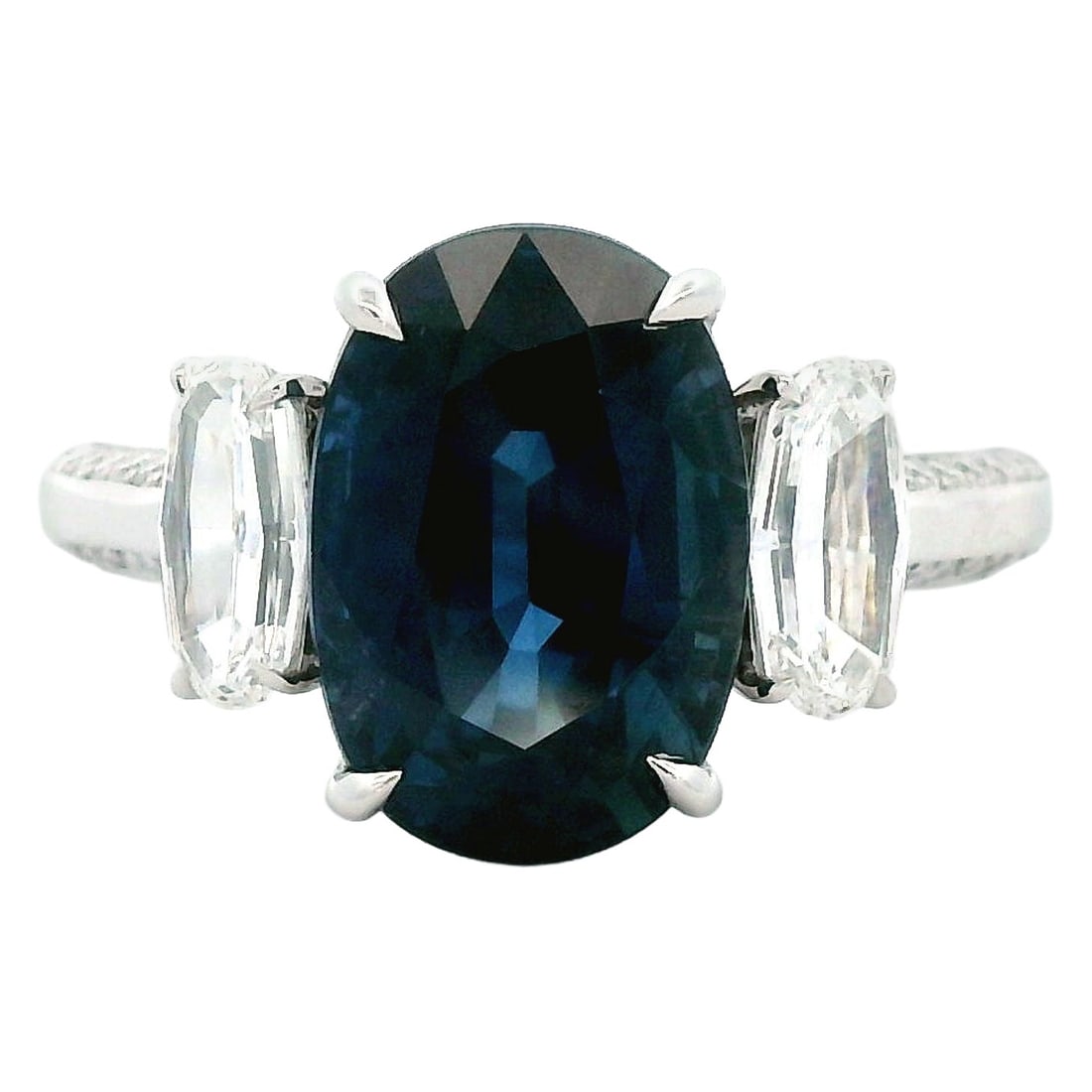 Platinum 3-Stone Ring 4.57ct No-Heat Oval Sapphire: Platinum 3-Stone Ring 4.57ct No-Heat Oval Sapphire Contemporary three-stone ring featuring a natural navy blue oval no-heat sapphire with diamond accents. The ring is platinum and includes an oval ste