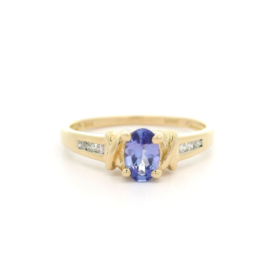 Elegant 14k Yellow Gold Oval Tanzanite Diamond Side Ring: Elegant 14k Yellow Gold Oval Tanzanite Diamond Side Ring This stunning ring features a natural oval tanzanite, set in solid 14k yellow gold, complemented by sparkling diamond accents. The tanzanite me
