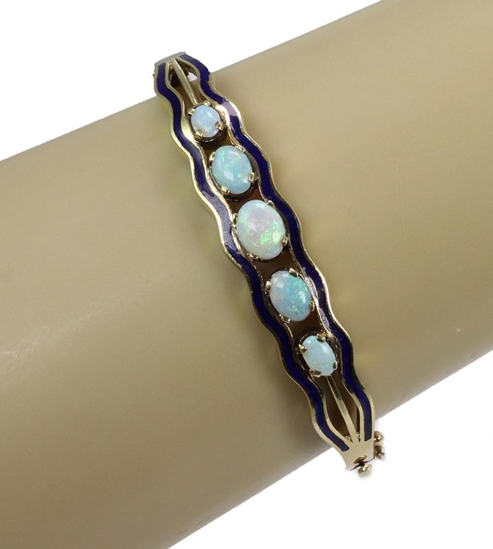 Unbranded Vintage 14k Yellow Gold Hinged Bangle Bracelet Blue Enamel Fire Opal: Unbranded Vintage 14k Yellow Gold Hinged Bangle Bracelet Blue Enamel Fire Opal This vintage hinged bangle bracelet is crafted in 14k yellow gold and features blue enamel accented with fire opals. It i