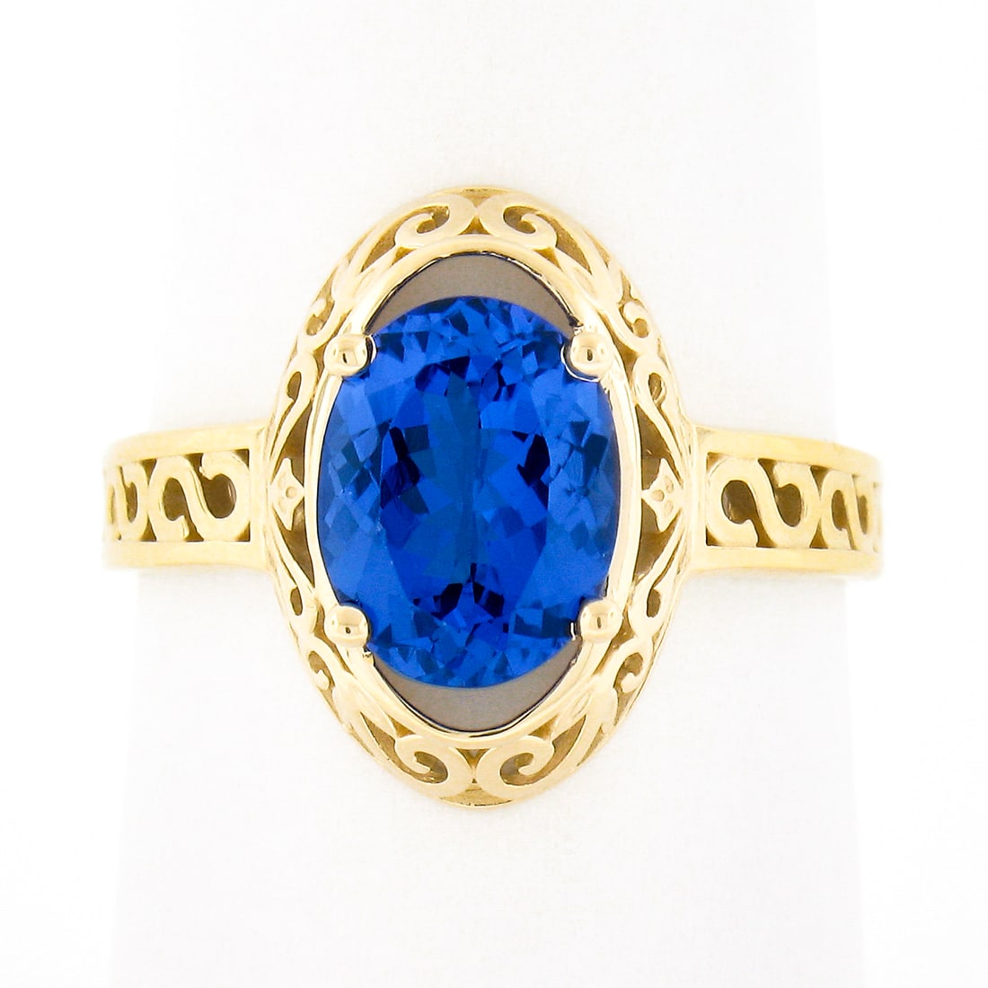 14K Yellow Gold 2.0ct Oval Tanzanite Solitaire Ring with Scroll Design: 14K Yellow Gold 2.0ct Oval Tanzanite Solitaire Ring with Scroll Design This exquisite solitaire ring features a stunning natural tanzanite gemstone, weighing approximately 2.0 carats, set in solid 14k
