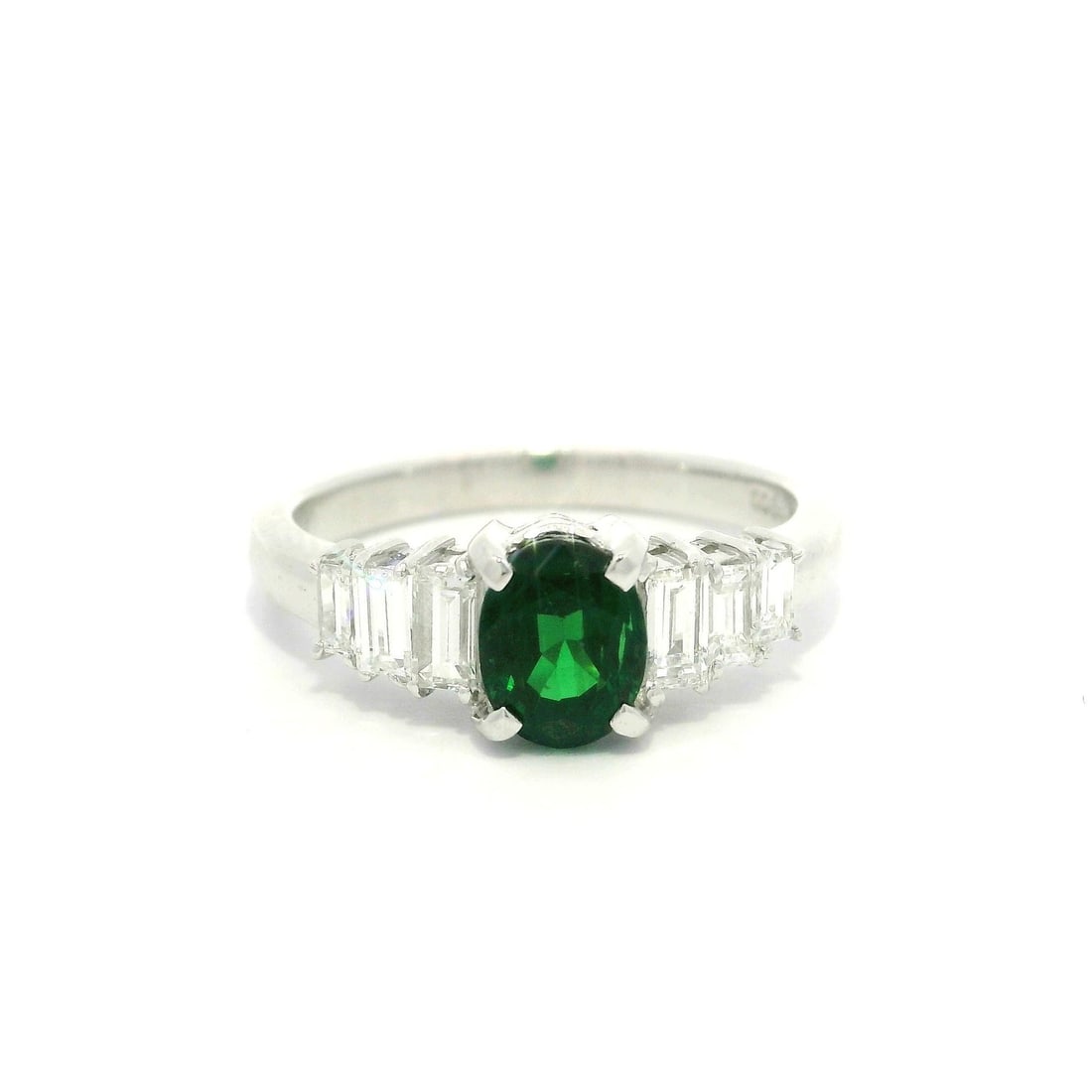Platinum 1.55ctw Oval Tsavorite Ring with Baguette Diamonds: Platinum 1.55ctw Oval Tsavorite Ring with Baguette Diamonds This exquisite band ring features a stunning natural oval-cut Tsavorite, prong set in solid platinum. The rich green hue of the Tsavorite, m