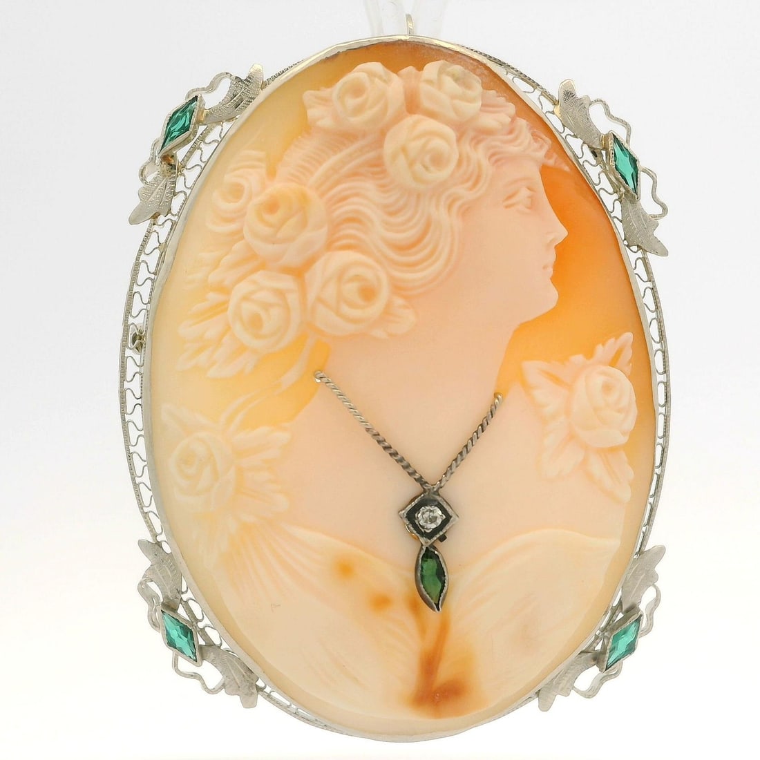 Vintage 12k White Gold Cameo Diamond Green Stone Brooch Pendant: Vintage 12k White Gold Cameo Diamond Green Stone Brooch Pendant This exquisite vintage pendant features a beautifully carved shell cameo, showcasing a peach base with white color carving. The piece is