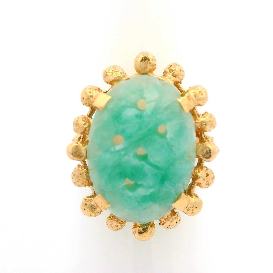 Vintage 14k Yellow Gold Jade Cabochon Cocktail Ring: Vintage 14k Yellow Gold Jade Cabochon Cocktail Ring This exquisite vintage cocktail ring showcases a stunning carved jade cabochon, elegantly set in solid 14k yellow gold. The oval-shaped jade, featur