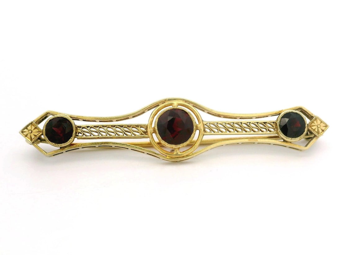 Antique Art Deco 14k Yellow Gold Garnet Open Work Bar Pin: Antique Art Deco 14k Yellow Gold Garnet Open Work Bar Pin This exquisite Antique Art Deco bar pin features a stunning arrangement of three natural garnets, each expertly cut in a round brilliant shape