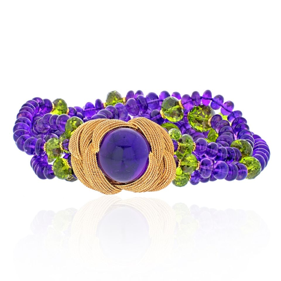 David Webb 18K Yellow Gold Amethyst Peridot Multistrand Bracelet: David Webb 18K Yellow Gold Amethyst Peridot Multistrand Bracelet This stunning David Webb bracelet features a luxurious design crafted from 18K yellow gold. The bracelet showcases three strands of smo