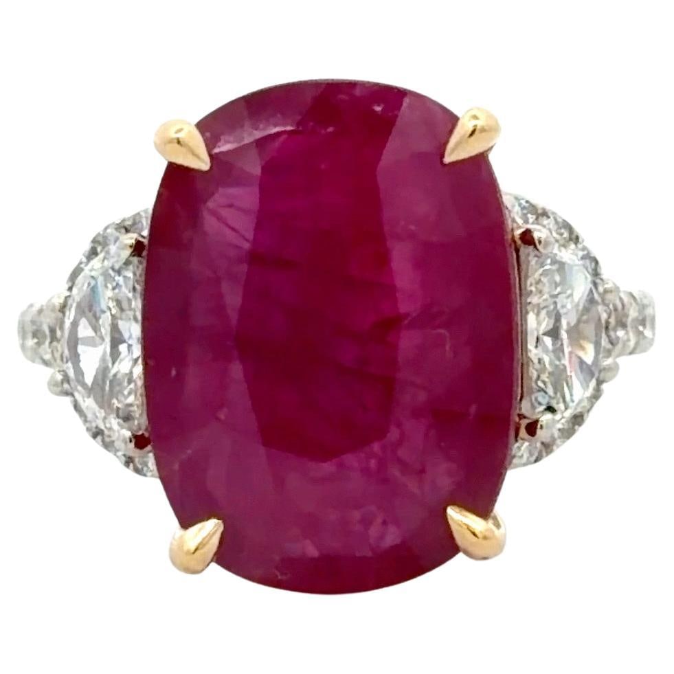 Oval 8.36ct Ruby Ring with Half Moon Diamonds in Two Tone 18k Gold: Oval 8.36ct Ruby Ring with Half Moon Diamonds in Two Tone 18k Gold This exceptional three-stone ring features a vibrant 8.36 carat oval ruby as its center stone, set in yellow gold prongs and basket t