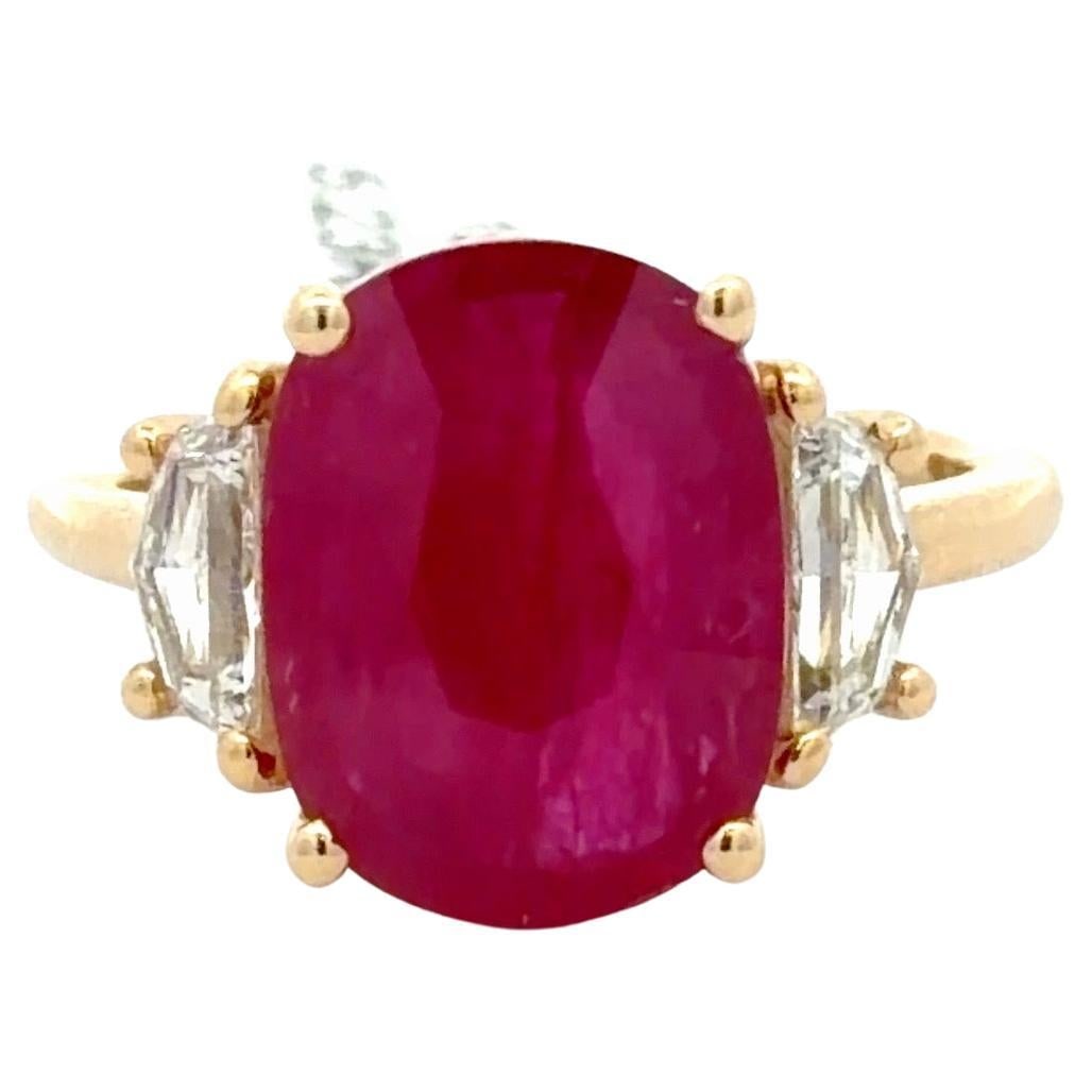 Three-Stone 18K Yellow Gold Ring with 5.23ct Oval Ruby and Cadillac Diamonds: Three-Stone 18K Yellow Gold Ring with 5.23ct Oval Ruby and Cadillac Diamonds This sophisticated three-stone ring is crafted from 18K yellow gold and features a vivid 5.23 carat oval-cut ruby as its ce