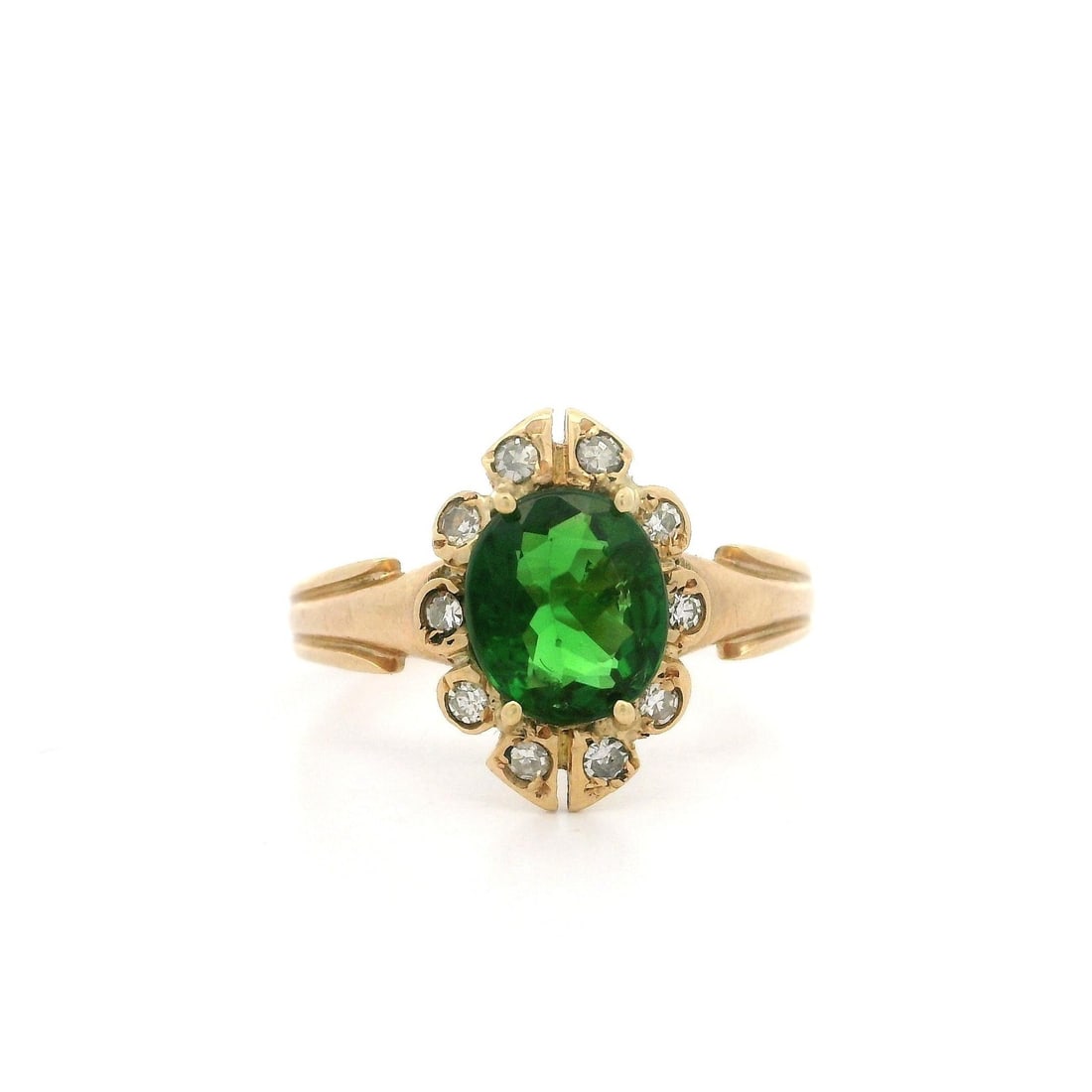 Victorian Era 14k Rosy Yellow Gold Ring with Green Tourmaline and Diamond Halo: Victorian Era 14k Rosy Yellow Gold Ring with Green Tourmaline and Diamond Halo This antique Victorian cocktail ring features a vivid green, natural oval-cut tourmaline as the centerpiece, surrounded b