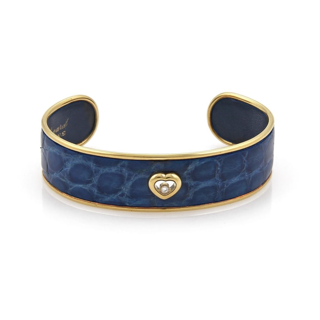 Chopard Happy Diamond 18k Gold Heart Cuff with Blue Leather: Chopard Happy Diamond 18k Gold Heart Cuff with Blue Leather Elevate your style with this exquisite Chopard Happy Diamond cuff bracelet, crafted from 18k yellow gold. This chic piece features a strikin