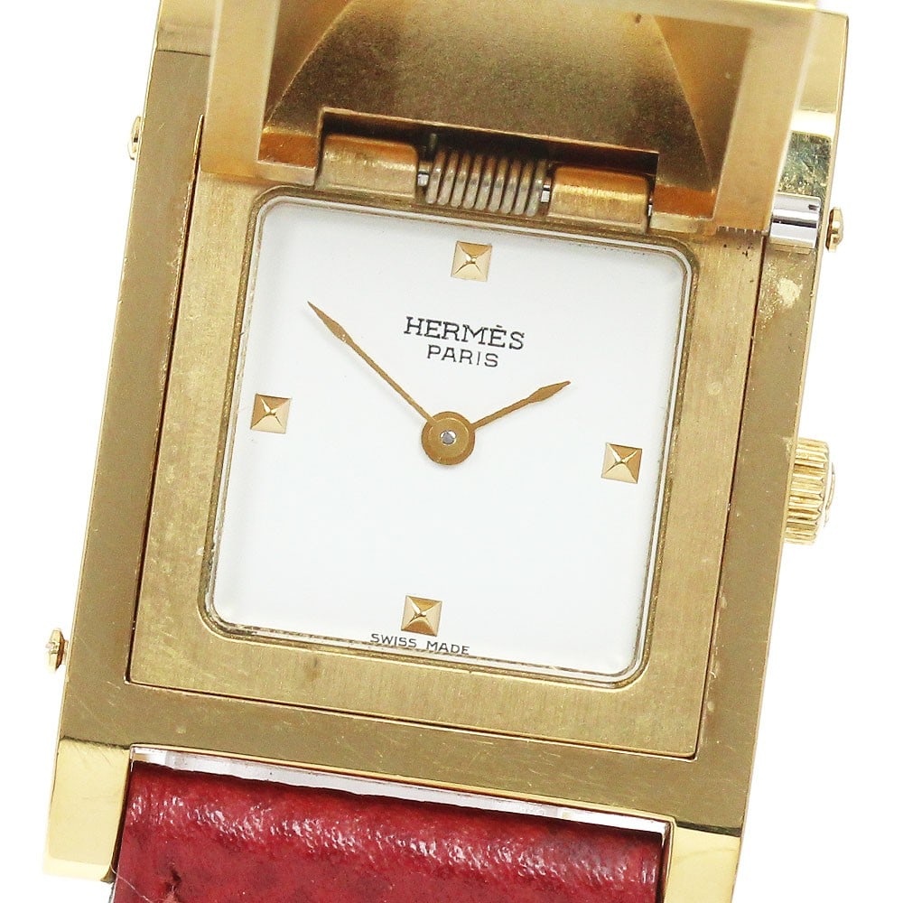 Hermes Medor quartz ladies wristwatch stainless steel GP leather strap: Hermes Medor quartz ladies wristwatch stainless steel GP leather strap This pre-owned HERMES Medor Quartz women's wristwatch features a stainless steel and gold-plated case paired with a white dial an
