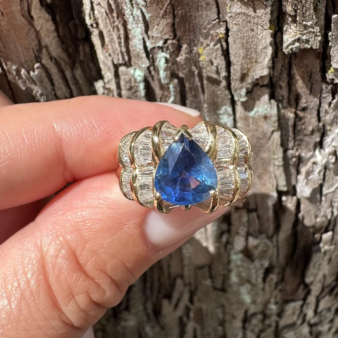 Unbranded 18k Yellow Gold Ring with GIA Pear Sapphire and Baguette Diamonds: Unbranded 18k Yellow Gold Ring with GIA Pear Sapphire and Baguette Diamonds Statement ring crafted in solid 18k yellow gold and set with a natural pear-cut blue sapphire accented by numerous baguette-