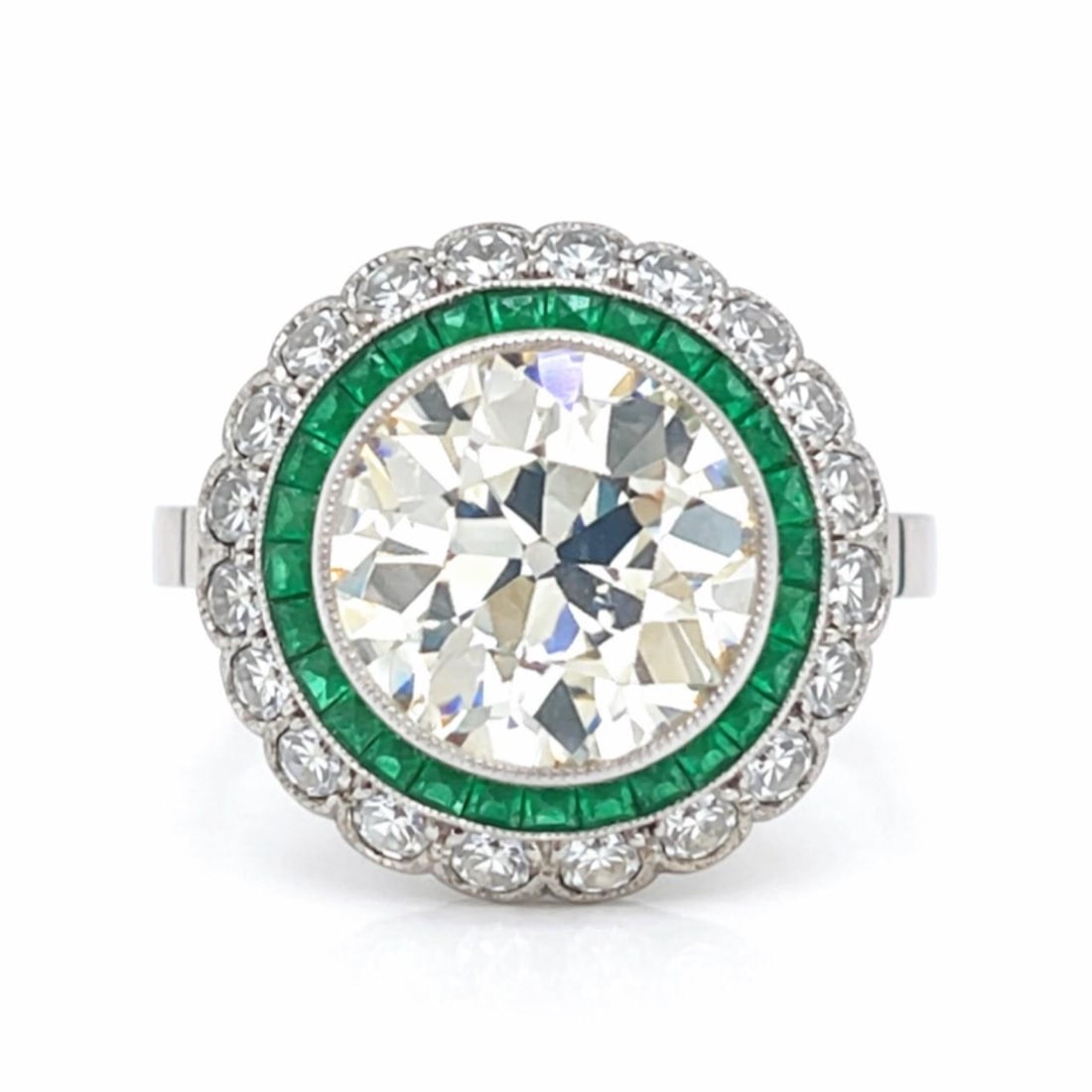 Platinum Art Deco Ring with 3.15 Ct Diamond and Emerald Accents: Platinum Art Deco Ring with 3.15 Ct Diamond and Emerald Accents This Art Deco ring features a platinum setting adorned with an approximately 3.15 carat Old Mine diamond of M-N color and VS2 clarity. A