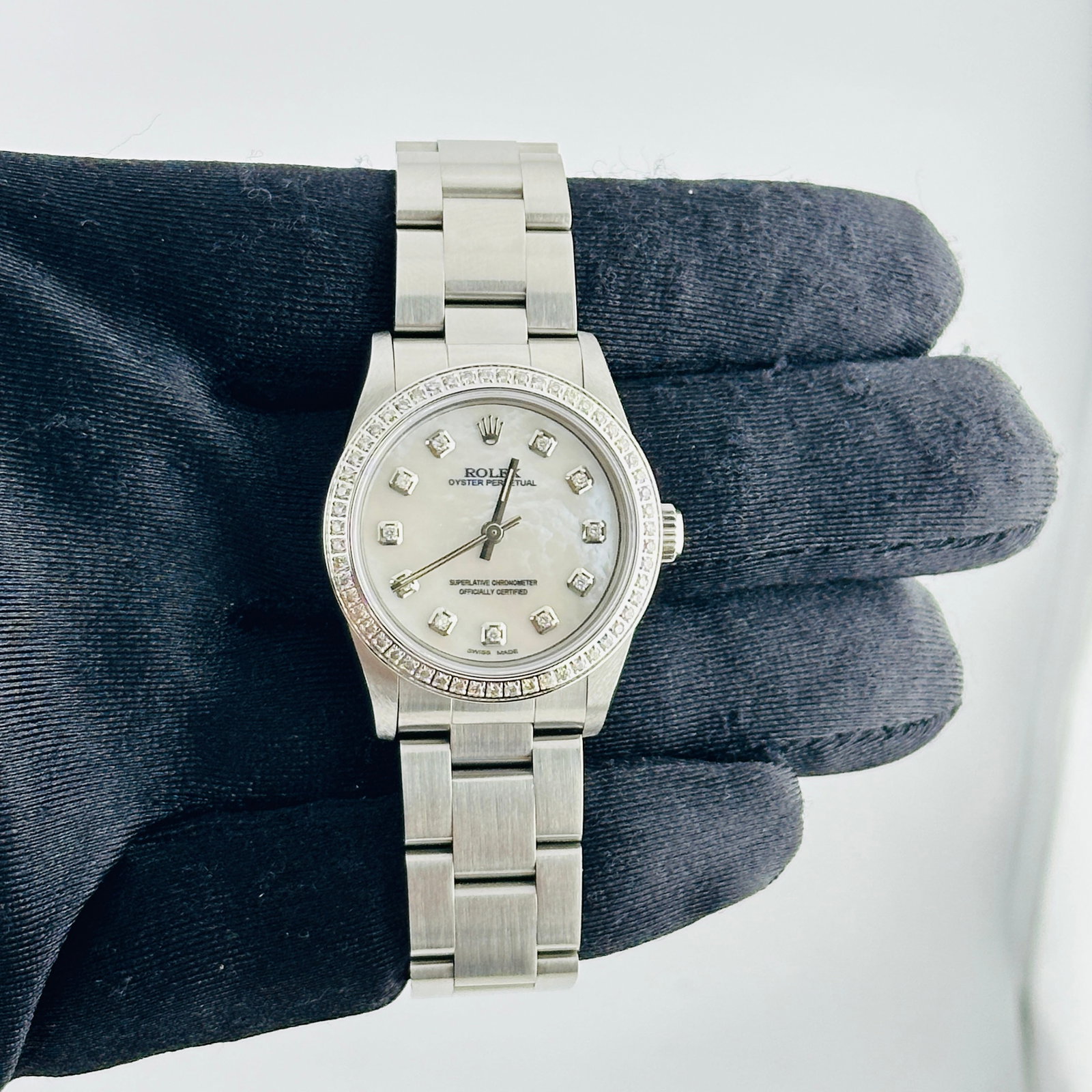 Ladies Rolex Oyster Perpetual 77080 White MOP Diamond Dial Oyster Bracelet: Ladies Rolex Oyster Perpetual 77080 White MOP Diamond Dial Oyster Bracelet This Rolex Oyster Perpetual watch features an aftermarket white mother-of-pearl dial adorned with diamond markers. The bezel 