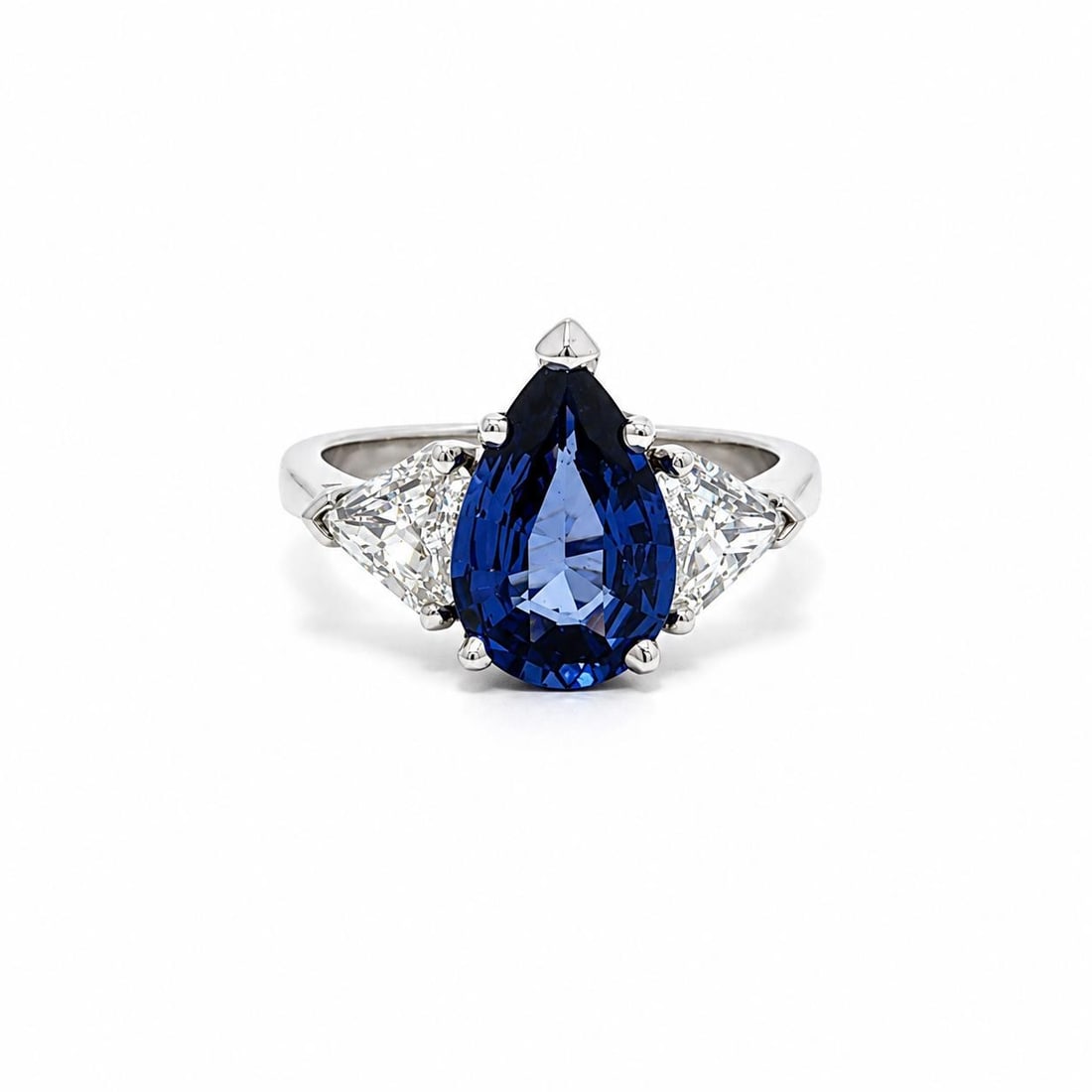 Unbranded GIA sapphire ring in 18k white gold with shield cut diamonds: Unbranded GIA sapphire ring in 18k white gold with shield cut diamonds Elegant cocktail ring featuring a natural pear-cut blue sapphire accented by two modified shield step cut diamonds in solid 18k w