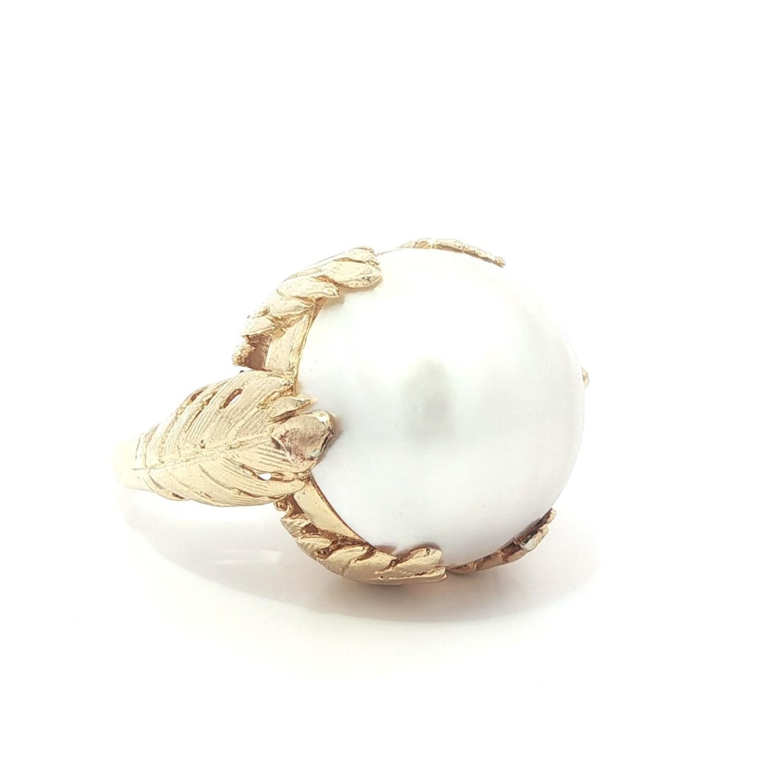 17.8mm Mabe Pearl Solitaire Ring in 14k Yellow Gold with Leaf Prong Detailing: 17.8mm Mabe Pearl Solitaire Ring in 14k Yellow Gold with Leaf Prong Detailing This vintage solitaire ring features a large, round genuine cultured mabe pearl with a white hue and light pink overtone, 