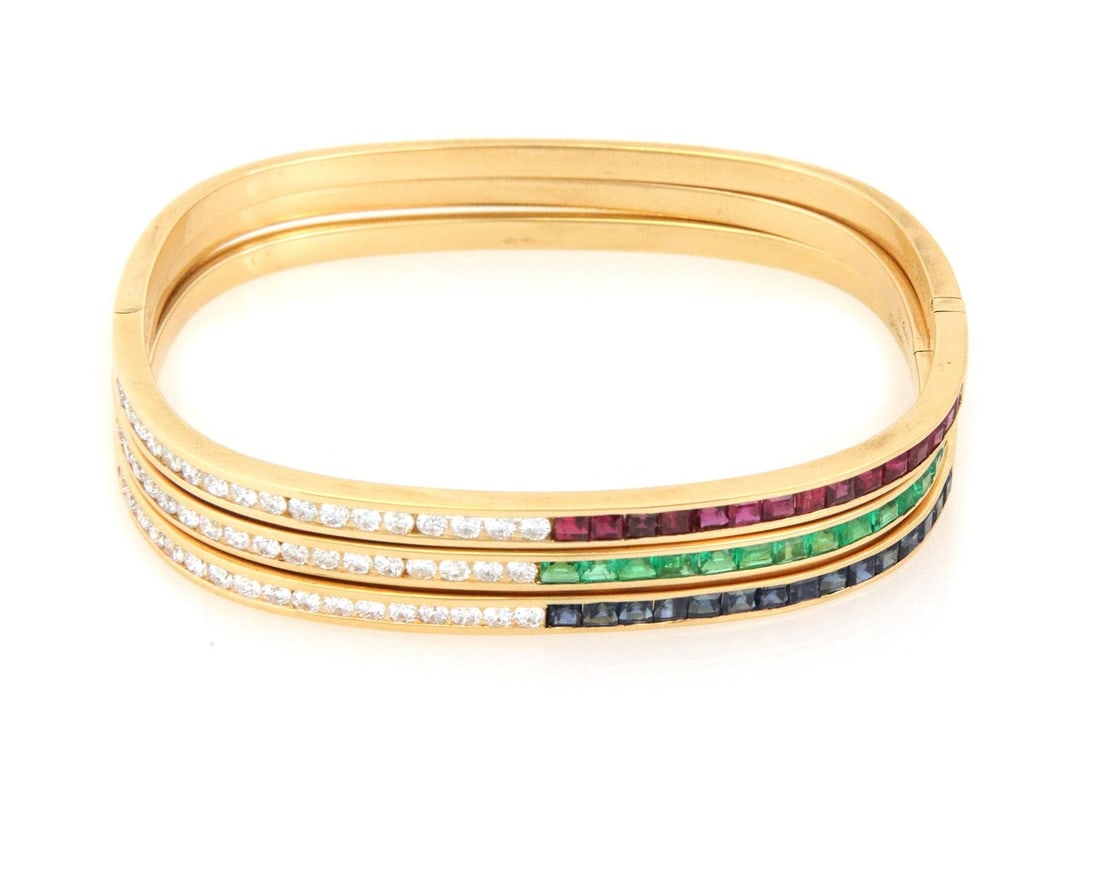Elegant 18k Gold Ruby Emerald Sapphire Diamond Bangle Set: Elegant 18k Gold Ruby Emerald Sapphire Diamond Bangle Set Enhance your jewelry collection with this exquisite set of three hinge bangles, crafted from 18k yellow gold. Each bangle features a unique de