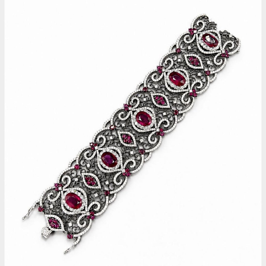 Diamond and Ruby Bracelet in 18K White Gold 7 x 1.75 inches: Diamond and Ruby Bracelet in 18K White Gold 7 x 1.75 inches Pre-owned bracelet crafted in 18K white gold and set with diamonds and rubies, including glass-filled rubies. This piece features a substant