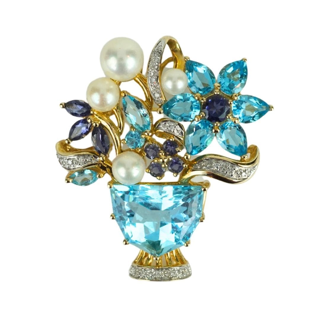 Custom 14K Yellow Gold Flower Brooch with Blue Topaz Tanzanite Pearls: Custom 14K Yellow Gold Flower Brooch with Blue Topaz Tanzanite Pearls Custom floral brooch crafted in 14K yellow gold and set with a blue topaz center stone, accented by small diamonds, tanzanite, and