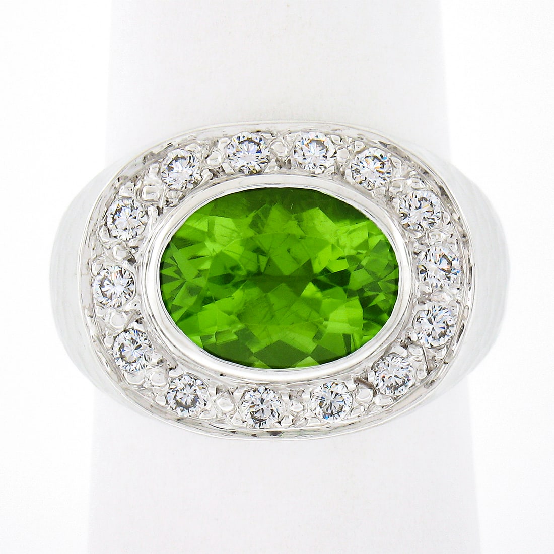 18k White Gold 4.11ctw Oval Peridot & Diamond Pave Cocktail Ring: 18k White Gold 4.11ctw Oval Peridot & Diamond Pave Cocktail Ring This exquisite cocktail ring features a stunning centerpiece of a natural oval peridot, weighing approximately 3.62 carats, with a vivi