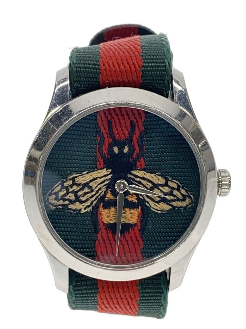 Gucci G Timeless quartz canvas green ladies wristwatch: Gucci G Timeless quartz canvas green ladies wristwatch This GUCCI G-TIMELESS Quartz Canvas 126.4 women's wristwatch features a green canvas strap and a Swiss-made quartz movement. The watch shows slig
