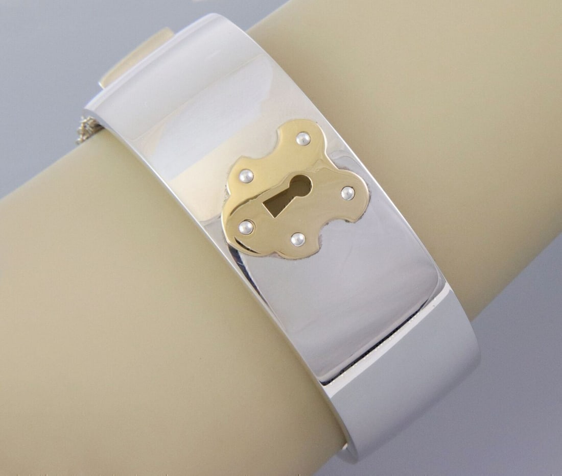 Tiffany & Co. Key Lock Wide Bangle Bracelet Sterling Silver 18k Gold: Tiffany & Co. Key Lock Wide Bangle Bracelet Sterling Silver 18k Gold Tiffany & Co. wide key lock bangle bracelet with a bold sculptural design in sterling silver and 18k yellow gold. The polished silh