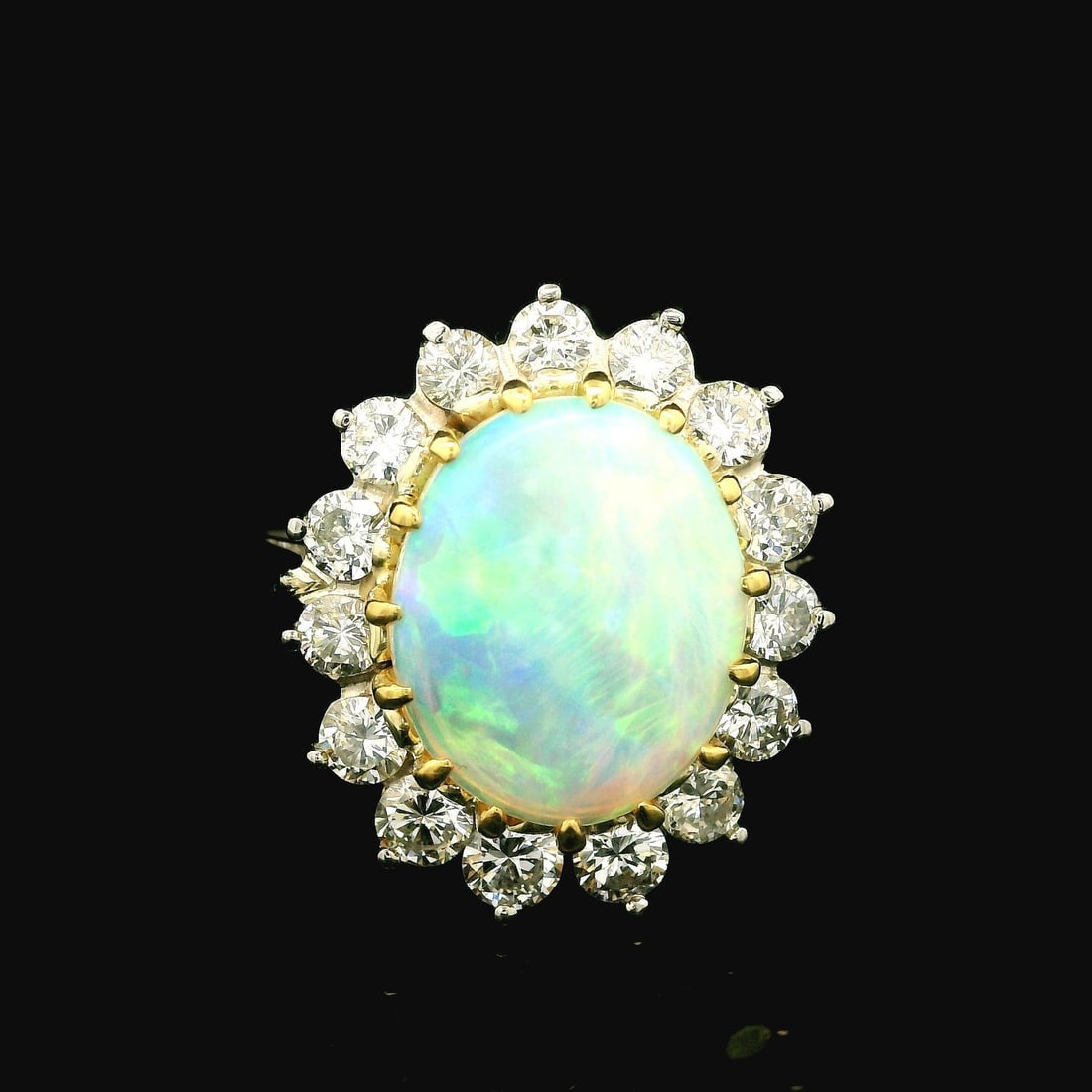 Vintage Opal Diamond Halo Cocktail Ring in Platinum and Yellow Gold: Vintage Opal Diamond Halo Cocktail Ring in Platinum and Yellow Gold Vintage cocktail ring featuring a natural opal cabochon surrounded by a diamond halo in a classic design. Crafted in solid .900+ pla