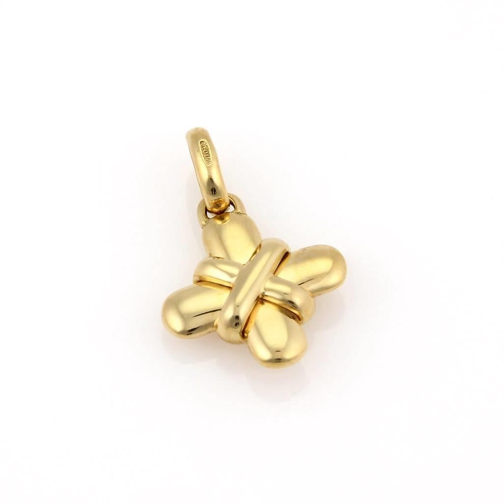 Bvlgari 18k Yellow Gold Cross Pendant with X Design: Bvlgari 18k Yellow Gold Cross Pendant with X Design This exquisite Bvlgari pendant is elegantly crafted from 18k yellow gold, showcasing a polished finish. The design features a stunning Cross with an