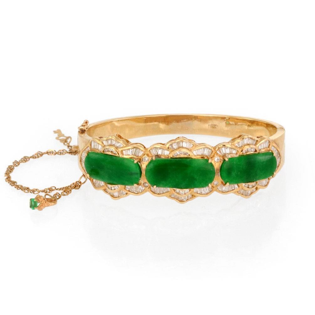 18k Yellow Gold Wide Bangle Bracelet with Jade and Diamond Floral Design: 18k Yellow Gold Wide Bangle Bracelet with Jade and Diamond Floral Design Estate wide bangle bracelet crafted in 18k yellow gold with a hinged band and floral-inspired front design. It features three d