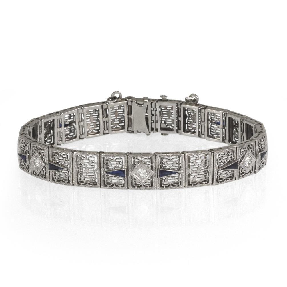 Art Deco 14k White Gold Filigree Bracelet with Diamond and Blue Stones: Art Deco 14k White Gold Filigree Bracelet with Diamond and Blue Stones This elegant Art Deco bracelet is crafted from 14k white gold and features a secure slide clasp with an attached safety chain for