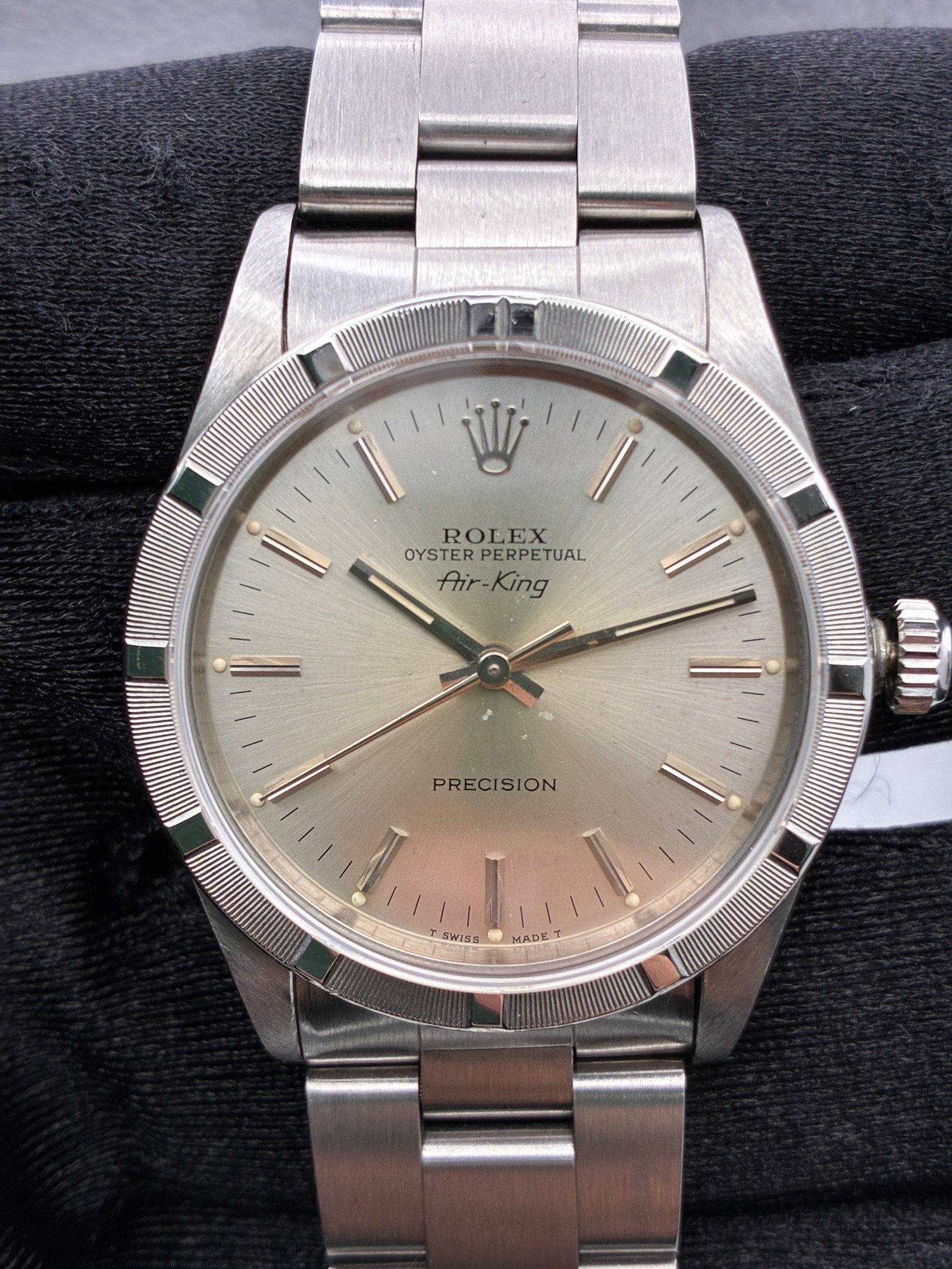 Rolex Air King 14010 Silver Dial Oyster Bracelet: Rolex Air King 14010 Silver Dial Oyster Bracelet This Rolex Air-King features a silver stick dial, an engine-turned bezel, and is paired with the iconic Oyster bracelet. The watch is designed for unis