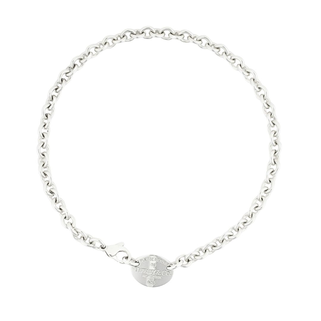 Tiffany & Co. Oval Sterling Silver Dog Tag Necklace 15 in: Tiffany & Co. Oval Sterling Silver Dog Tag Necklace 15 in This Tiffany & Co. sterling silver ID tag pendant necklace features a round link choker chain and an oval dog tag pendant stamped with Tiffany