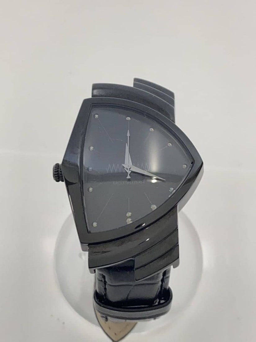 Hamilton Ventura Black Leather Quartz Men's Wristwatch H244010: Hamilton Ventura Black Leather Quartz Men's Wristwatch H244010 This Hamilton Ventura Quartz H244010 men's wristwatch features a black dial and a leather band. Crafted in Switzerland, this pre-owned wa