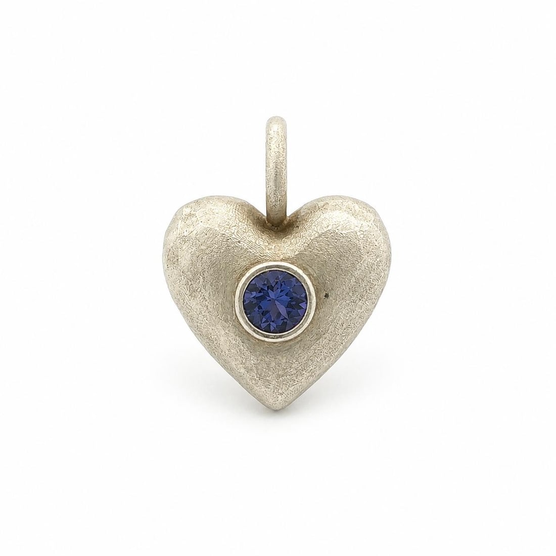 Unbranded Heart Pendant in Sterling Silver with Bezel Tanzanite: Unbranded Heart Pendant in Sterling Silver with Bezel Tanzanite Handmade heart pendant crafted in solid sterling silver with a hammered finish and a bezel-set natural tanzanite. This pre-owned piece s