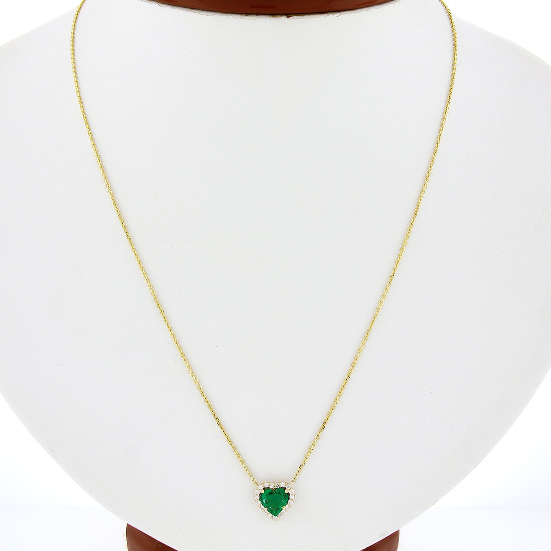14K Yellow Gold Heart Cut Emerald Diamond Halo Pendant Adjustable Chain: 14K Yellow Gold Heart Cut Emerald Diamond Halo Pendant Adjustable Chain This exquisite pendant necklace features a stunning heart cut emerald weighing 0.64 carats, beautifully surrounded by a halo of 