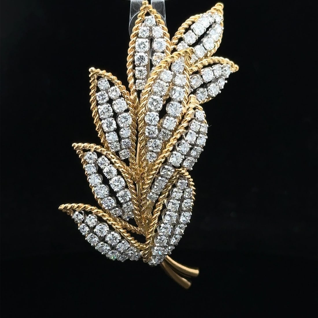 Vintage 6.5ctw Diamond Leaf Brooch in Gold and Platinum: Vintage 6.5ctw Diamond Leaf Brooch in Gold and Platinum This stunning vintage brooch features a captivating leaf floral design adorned with 107 genuine round brilliant cut diamonds, totaling approxima