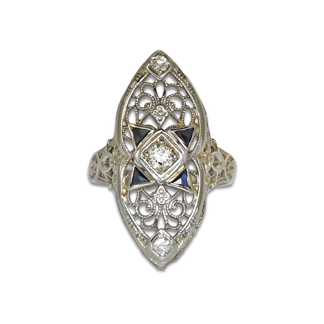 Art Deco 18K White Gold Spinel Diamond Ring Size 3.5: Art Deco 18K White Gold Spinel Diamond Ring Size 3.5 This Art Deco ring features a classic design with old European cut diamonds and blue spinel accents set in 18K white gold. The ring has intricate o