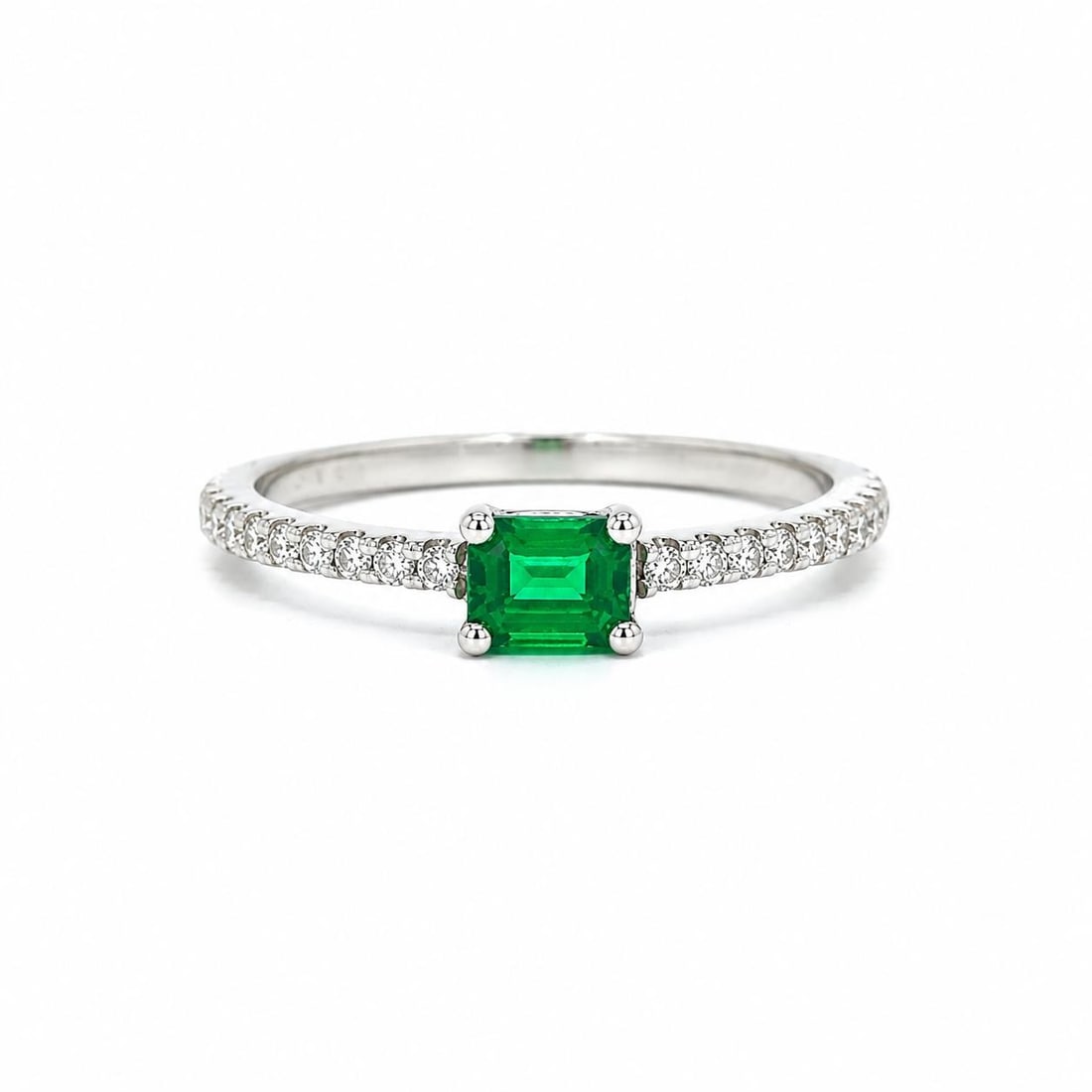 14k White Gold East West Emerald Ring with Diamond Accents: 14k White Gold East West Emerald Ring with Diamond Accents Cocktail ring for women featuring a natural rectangular step-cut emerald set east-west with diamond sides. The ring is made of solid 14k whit